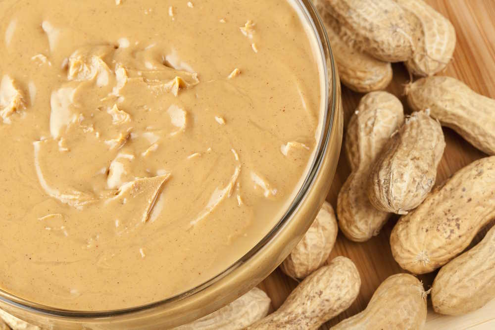 Creamy brown peanut butter and fresh peanuts