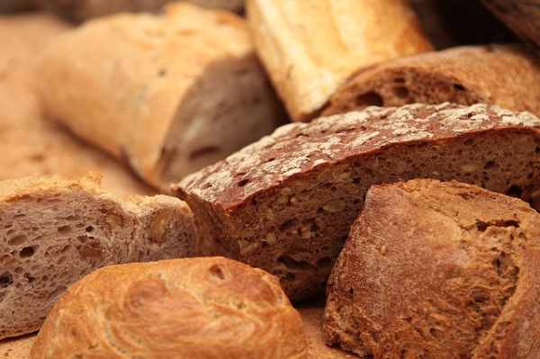 A variety of different types of loaves of bread and rolls.