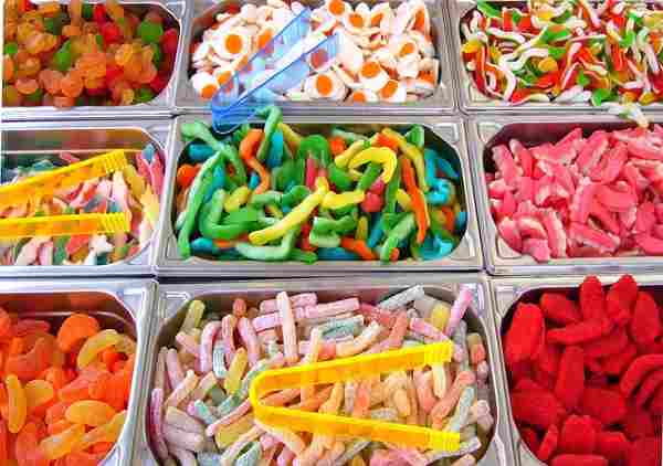 Nine different colorful candy assortment with tongs featured as a candy bar.