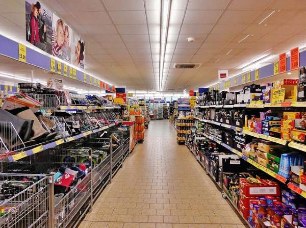 An isle in a large supermarket looking past two rows of food items.