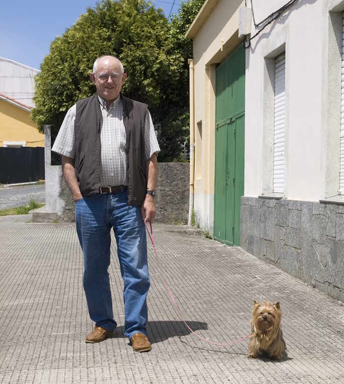 Elderly man is walking a small dog