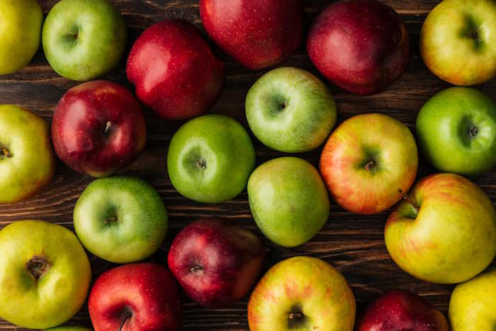 Fresh apples placed on a wooden table