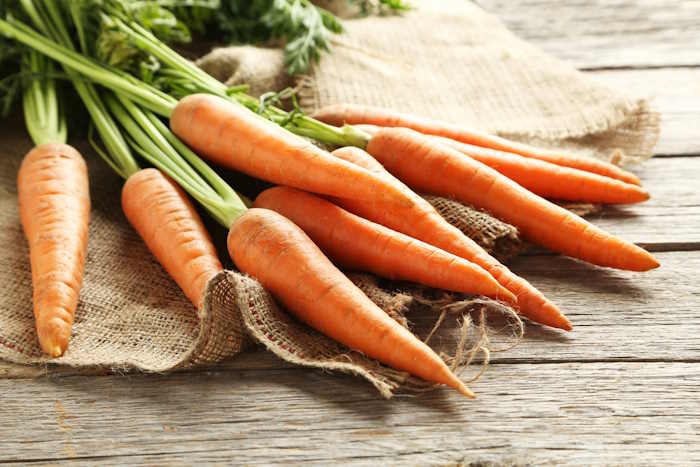 Fresh bunch of carrots on a wooden table