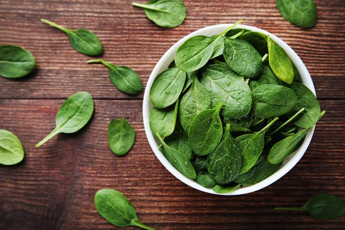 fresh spinach on wooden table