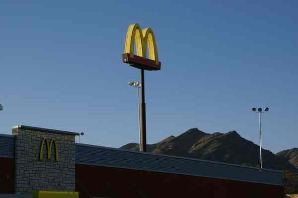 A picture of golden arches in front of the night sky.