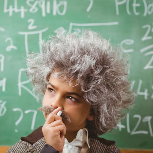Unusual Dog Names from Math and Science A young boy dressed as Enstein in front of a chalk board