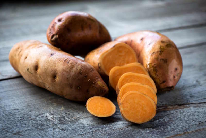 fresh sweet potatoes on table